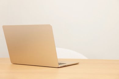 Photo of Modern laptop on wooden table. Space for text