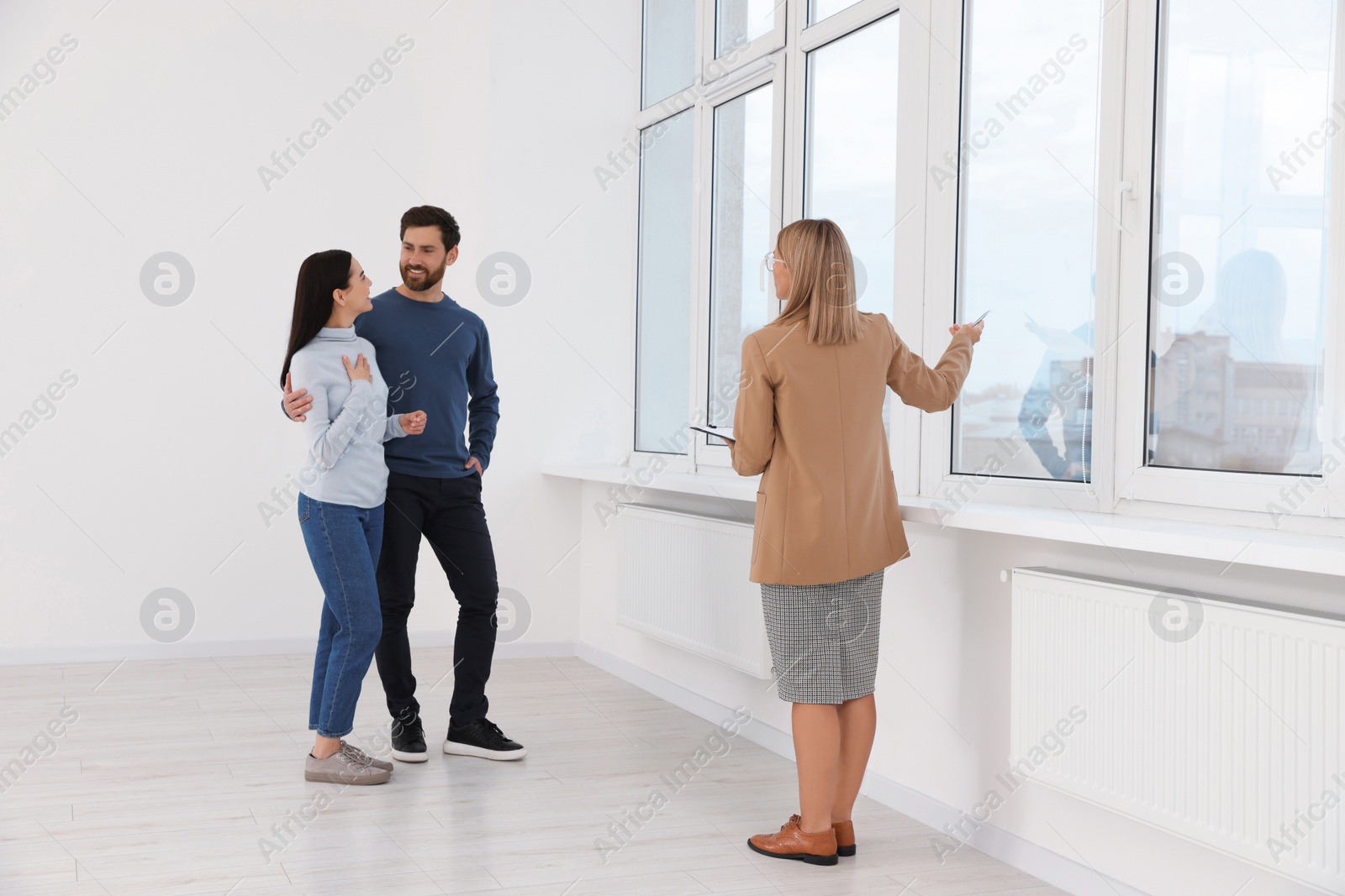 Photo of Real estate agent showing new apartment to couple