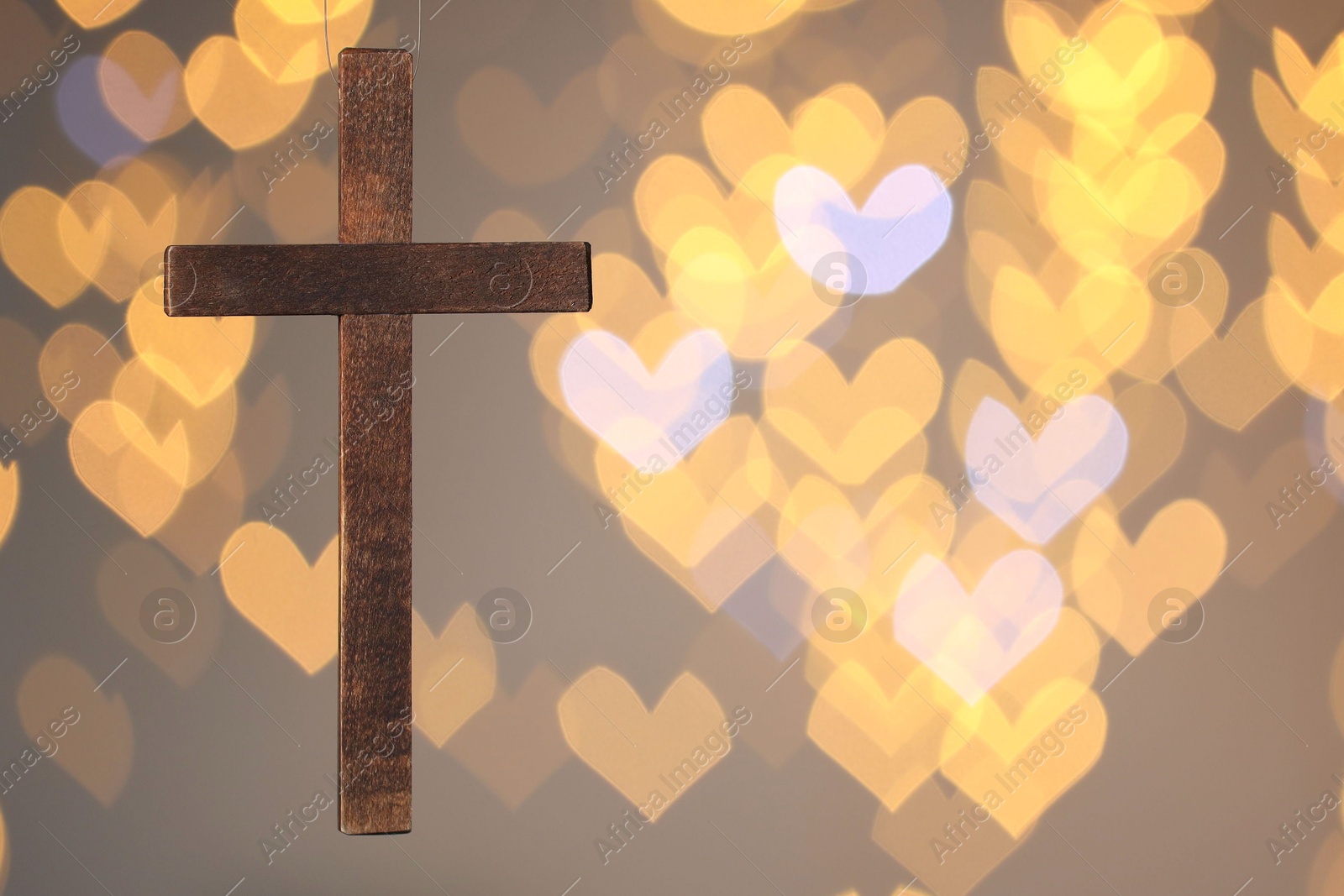 Photo of Wooden cross against blurred lights, closeup with space for text. Religion of Christianity