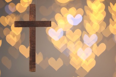 Photo of Wooden cross against blurred lights, closeup with space for text. Religion of Christianity