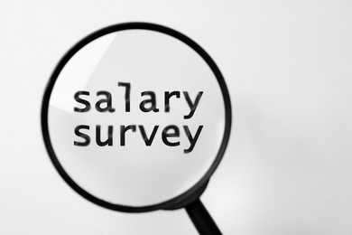 Phrase Salary Survey and magnifying glass on white background