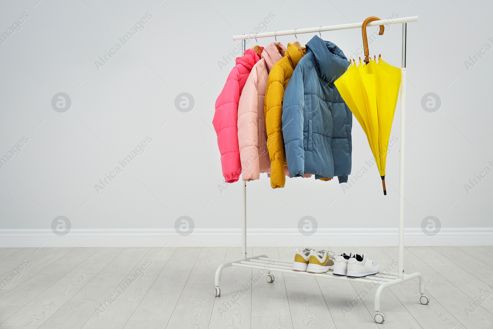 Photo of Rack with warm jackets in room. Space for text