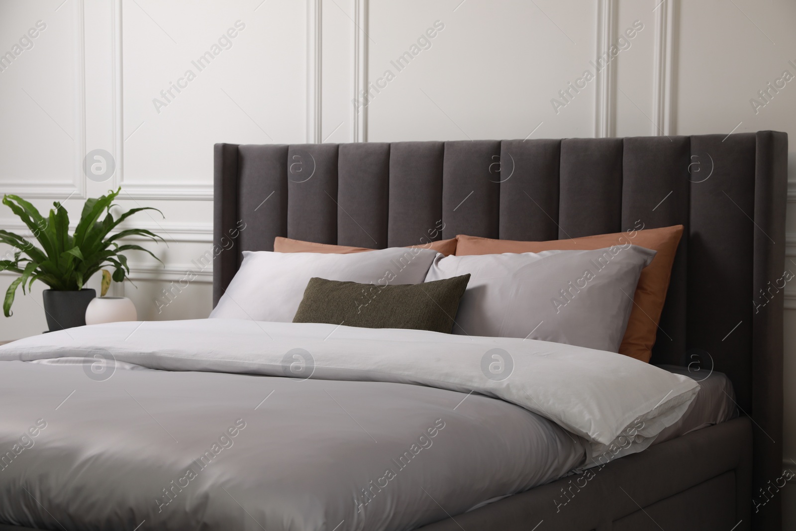 Photo of Comfortable bed with pillows and bedding in stylish room. Interior design