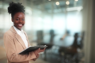 Lawyer, consultant, business owner. Confident woman with clipboard smiling indoors, space for text