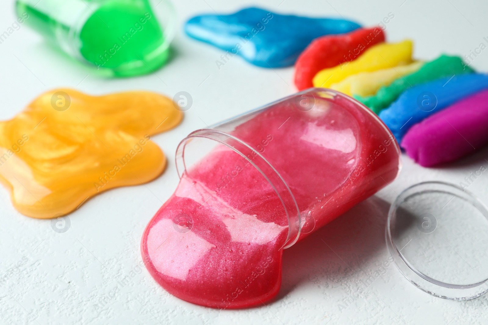 Photo of Different bright slimes on white background, closeup