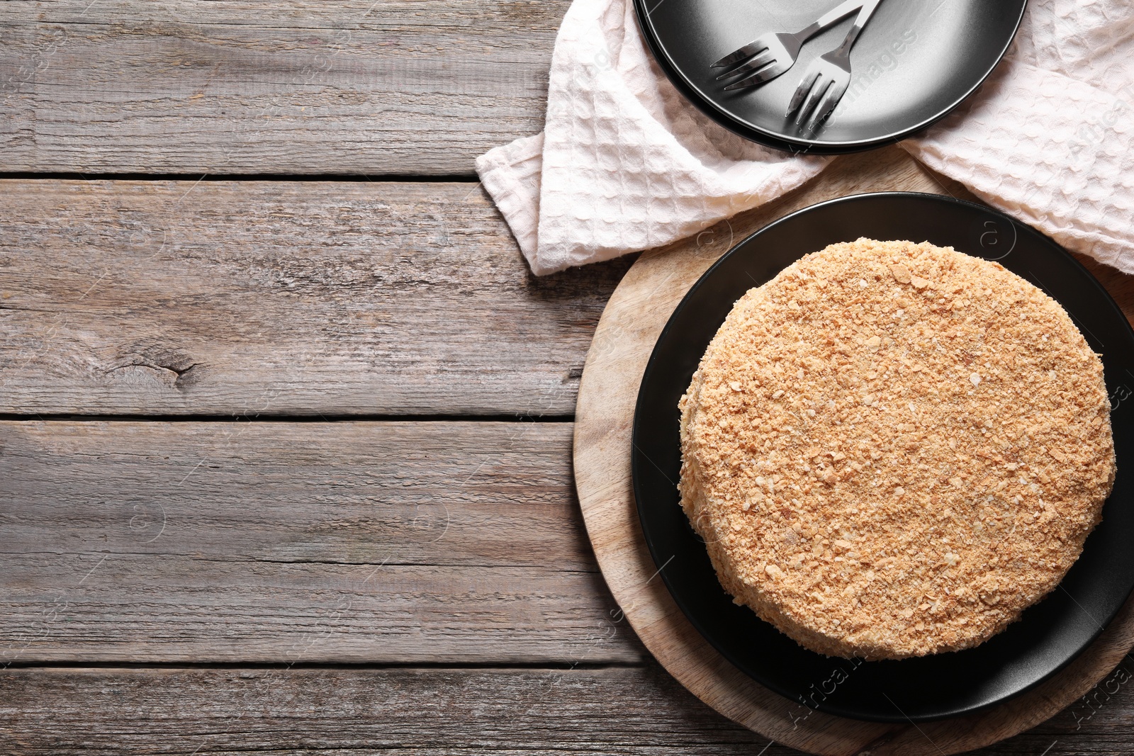 Photo of Delicious Napoleon cake on wooden table, top view. Space for text