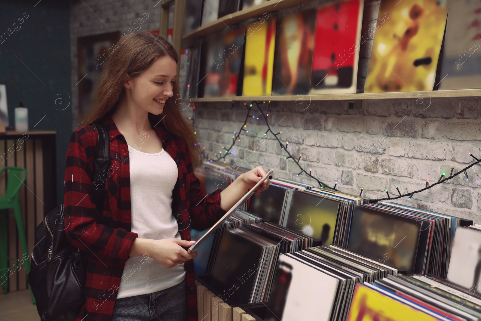 Image of Young woman with vinyl record in store