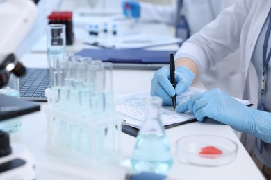 Laboratory worker working at white table, closeup