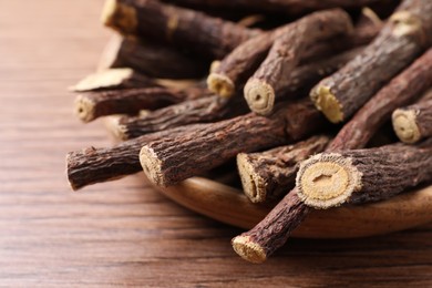 Dried sticks of liquorice root on wooden table, closeup