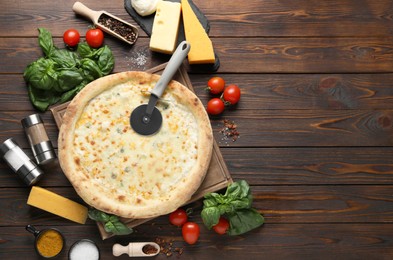 Flat lay composition with delicious cheese pizza and ingredients on wooden table. Space for text