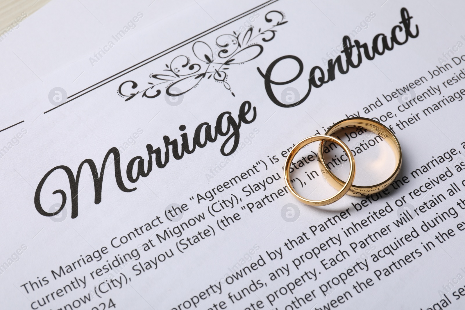 Photo of Marriage contract and gold rings on table, above view