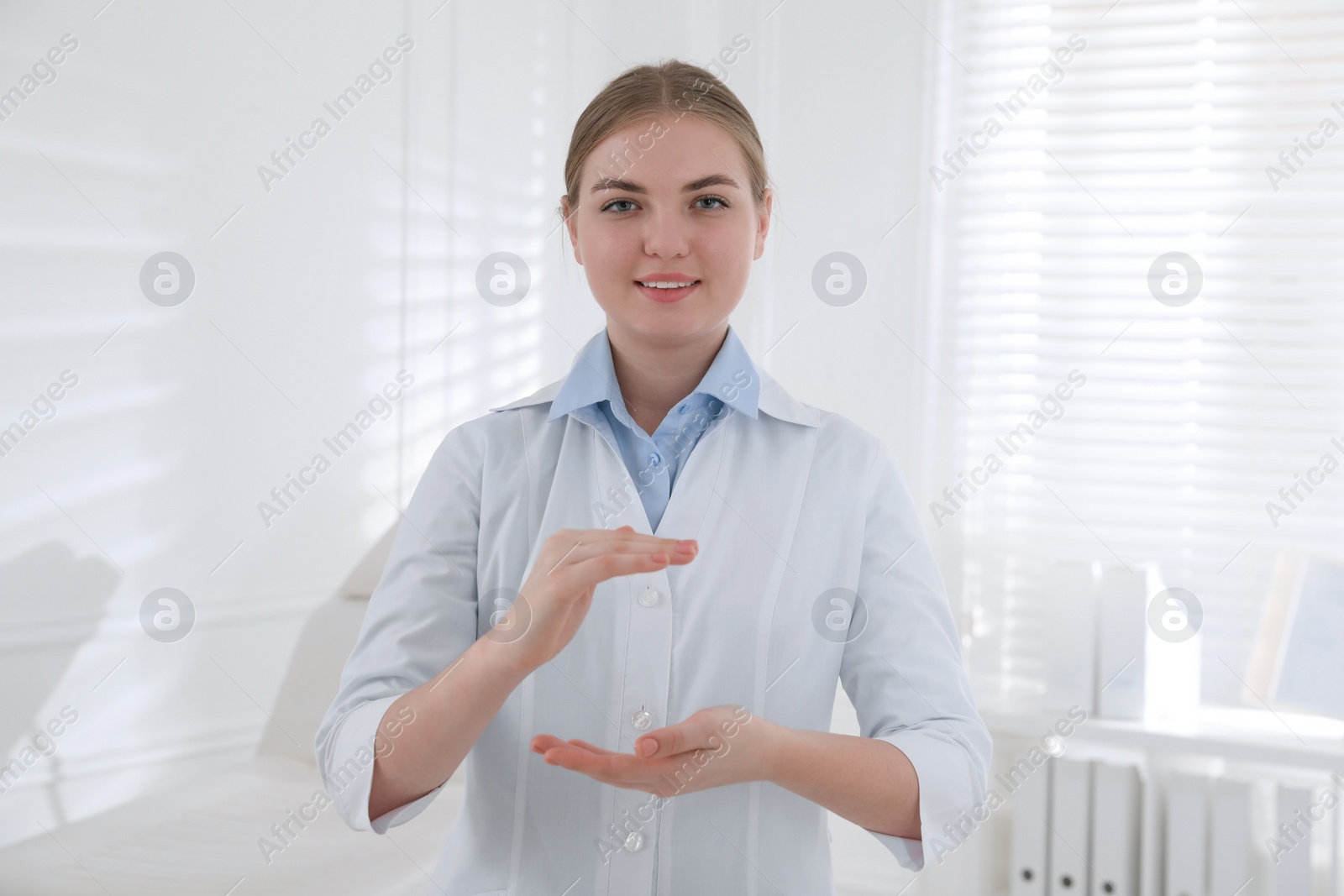 Photo of Happy dental assistant holding something in clinic