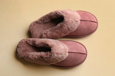 Pair of stylish soft slippers on beige background, flat lay