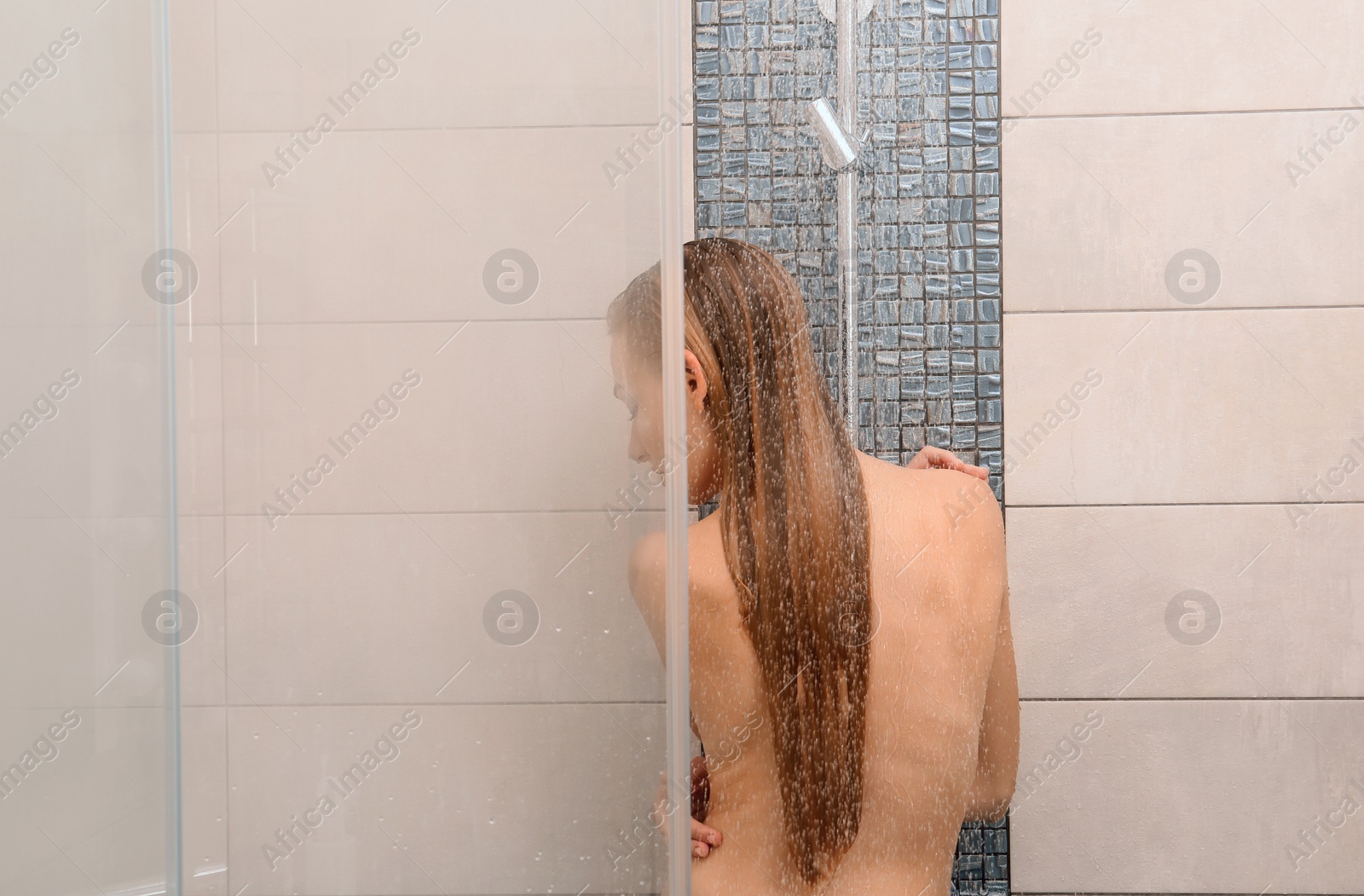 Photo of Beautiful young woman taking shower at home