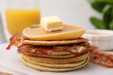 Delicious pancakes with bacon, butter and honey on table, closeup