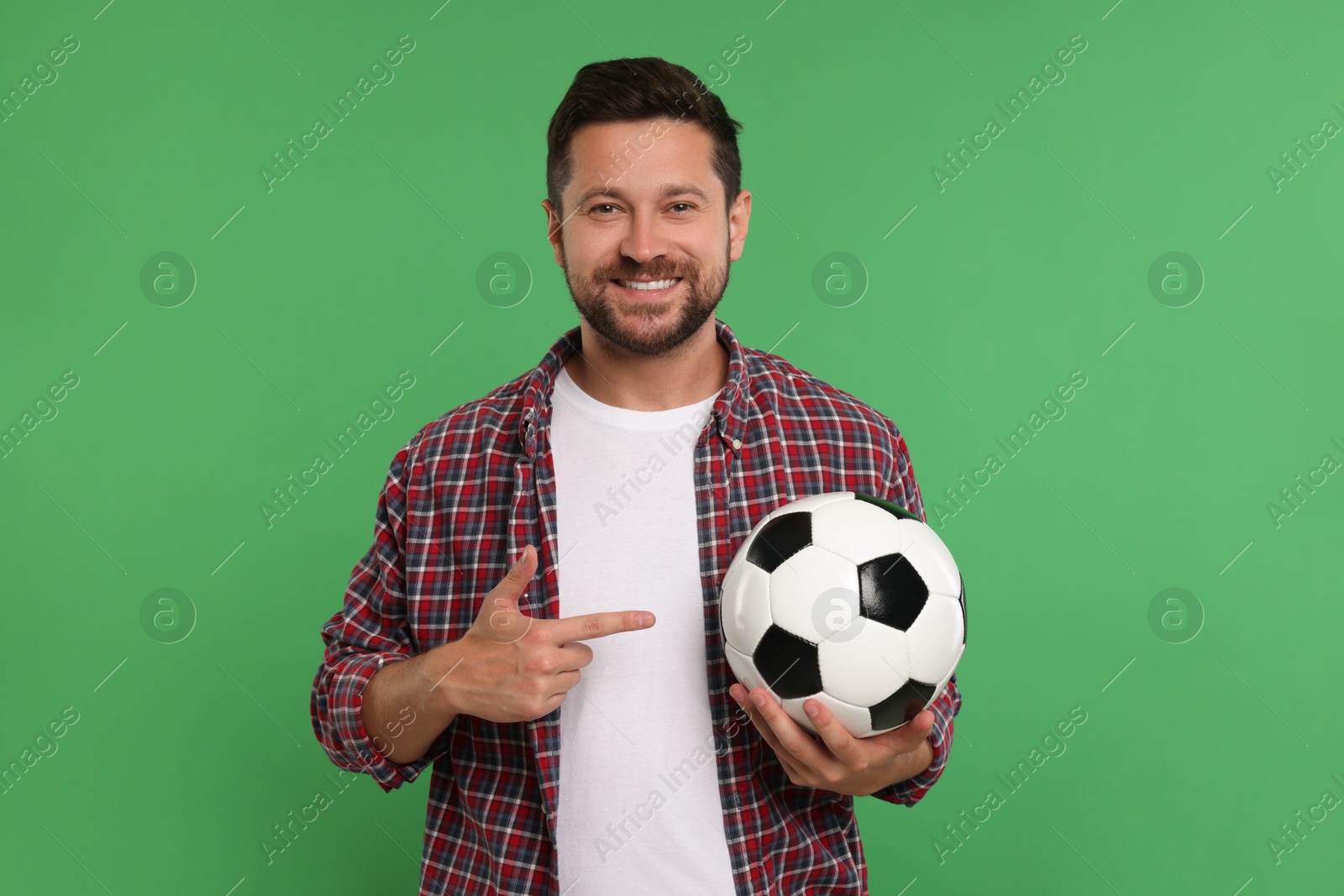 Photo of Happy sports fan with ball on green background