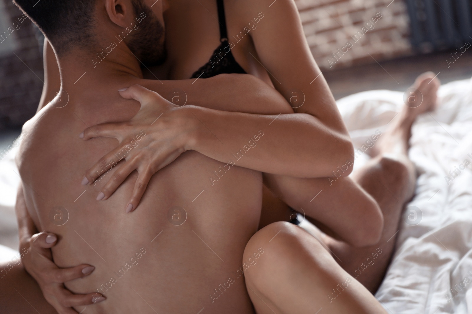 Photo of Passionate young couple having sex on bed at home, closeup