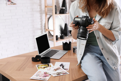Photo of Professional photographer with camera working in light modern office, closeup