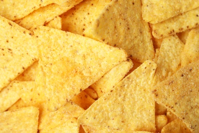 Photo of Tasty Mexican nachos chips as background, top view