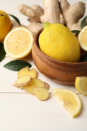 Photo of Fresh lemons and ginger on white wooden table, closeup