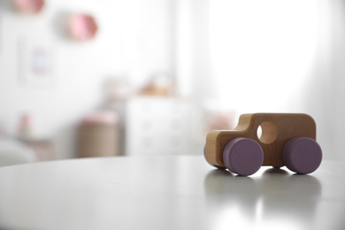 Wooden car on white table indoors. Space for text