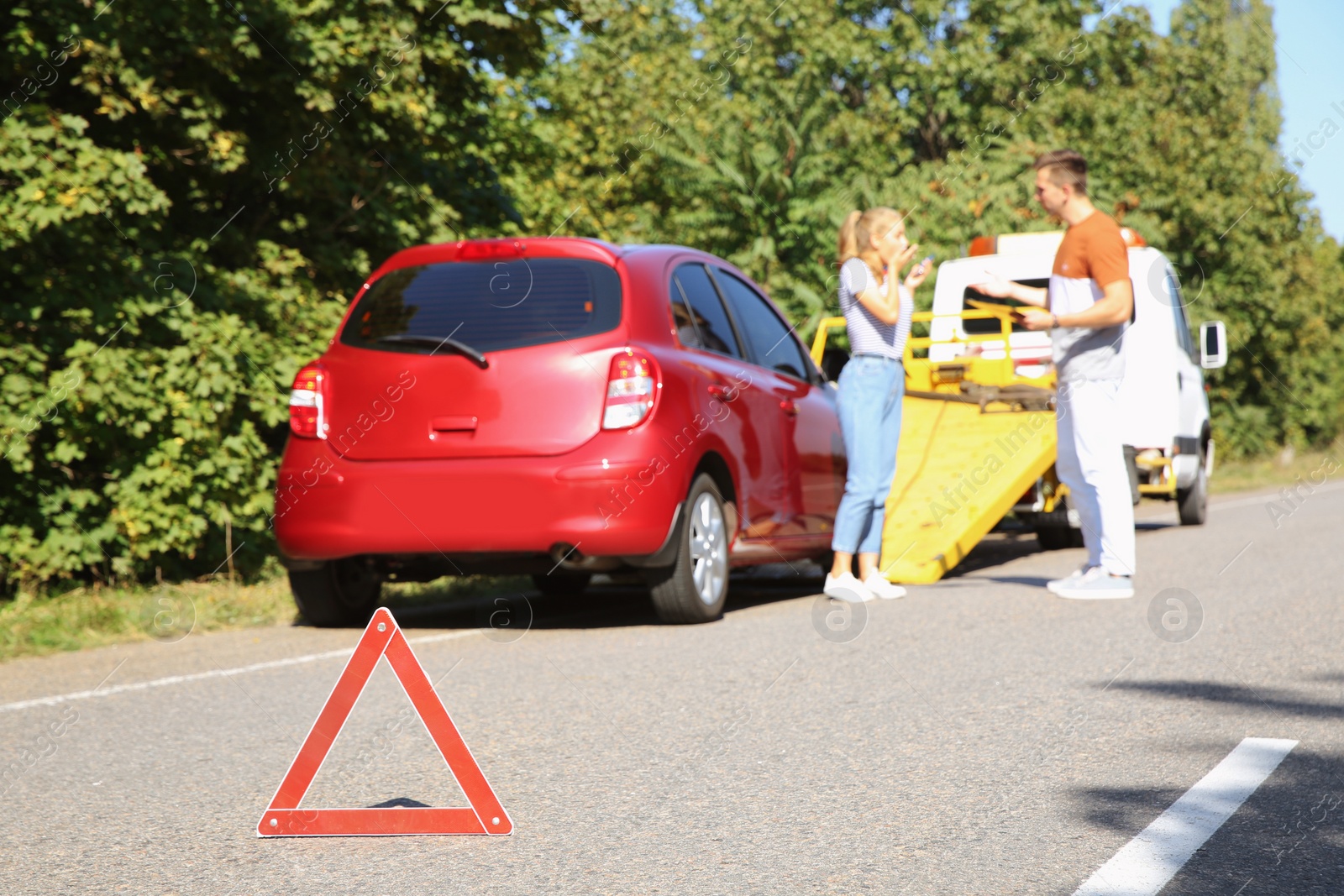 Photo of Emergency stop sign and people near broken car on background