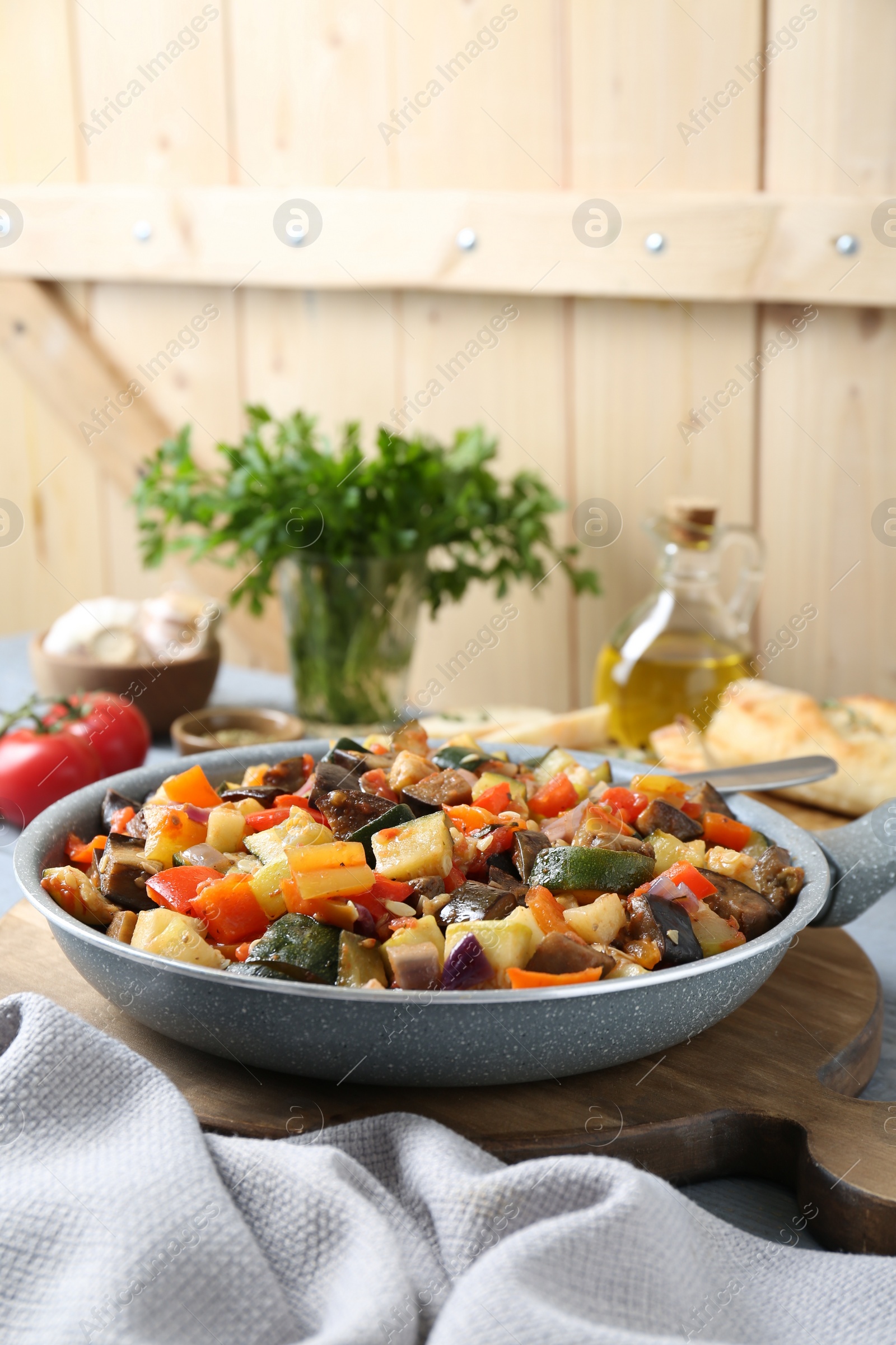 Photo of Delicious ratatouille in frying pan on table, space for text