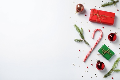 Flat lay composition with Christmas gifts and festive decor on white background. Space for text