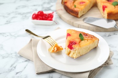 Eating piece of delicious pineapple pie with cherry and mint on white marble table