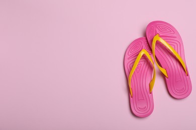 Photo of Stylish flip flops on pink background, flat lay. Space for text