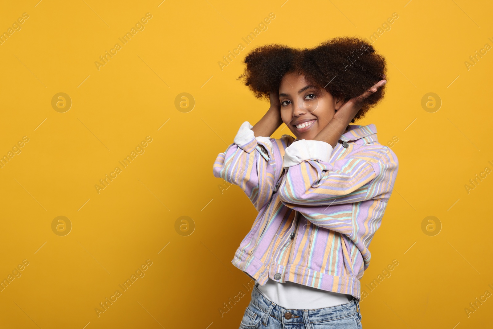 Photo of Portrait of smiling African American woman on orange background. Space for text