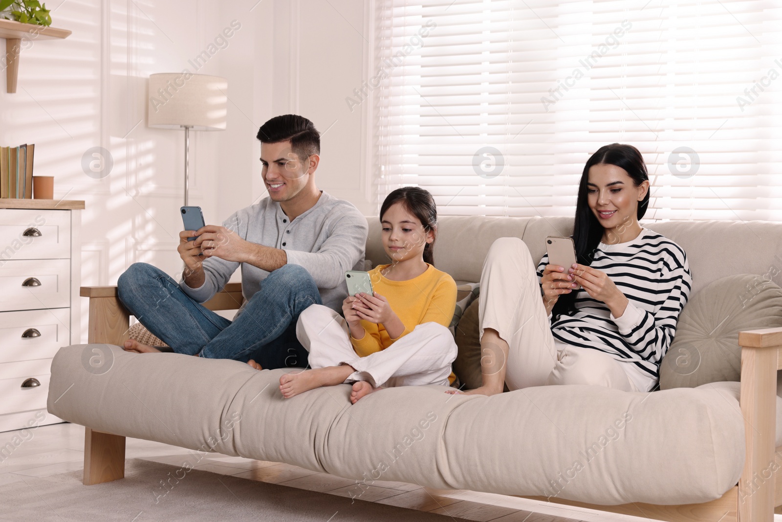 Photo of Internet addiction. Family with gadgets on sofa in living room