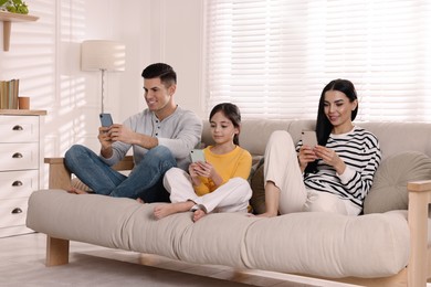 Photo of Internet addiction. Family with gadgets on sofa in living room