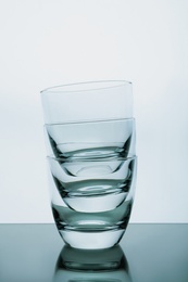 Photo of Stack of empty whiskey glasses on white background