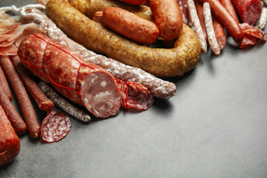 Different types of sausages on grey table