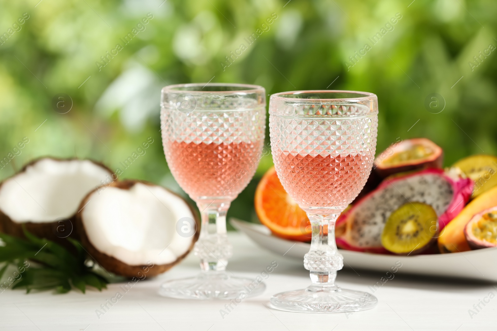 Photo of Delicious exotic fruits and wine on white table