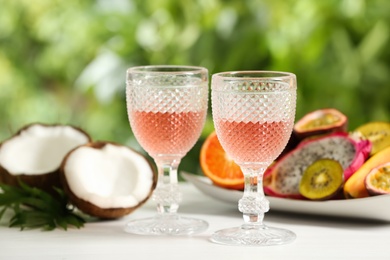 Photo of Delicious exotic fruits and wine on white table