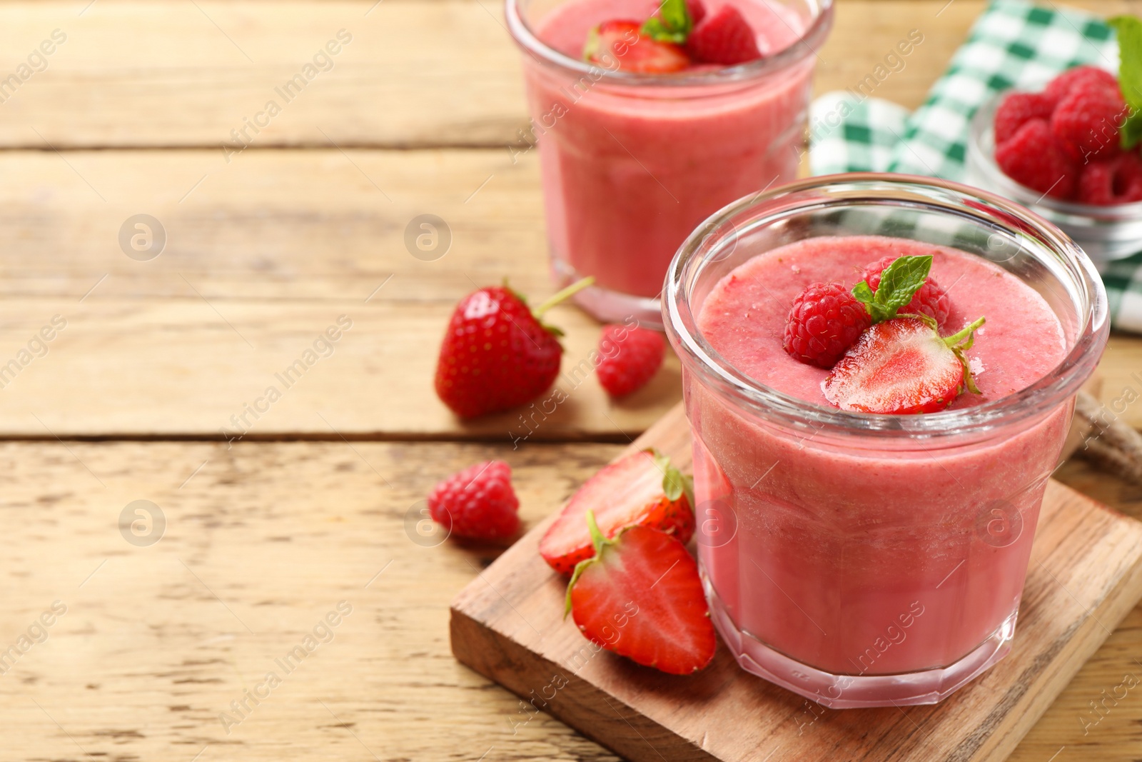 Photo of Delicious berry mousse with mint on wooden table, space for text