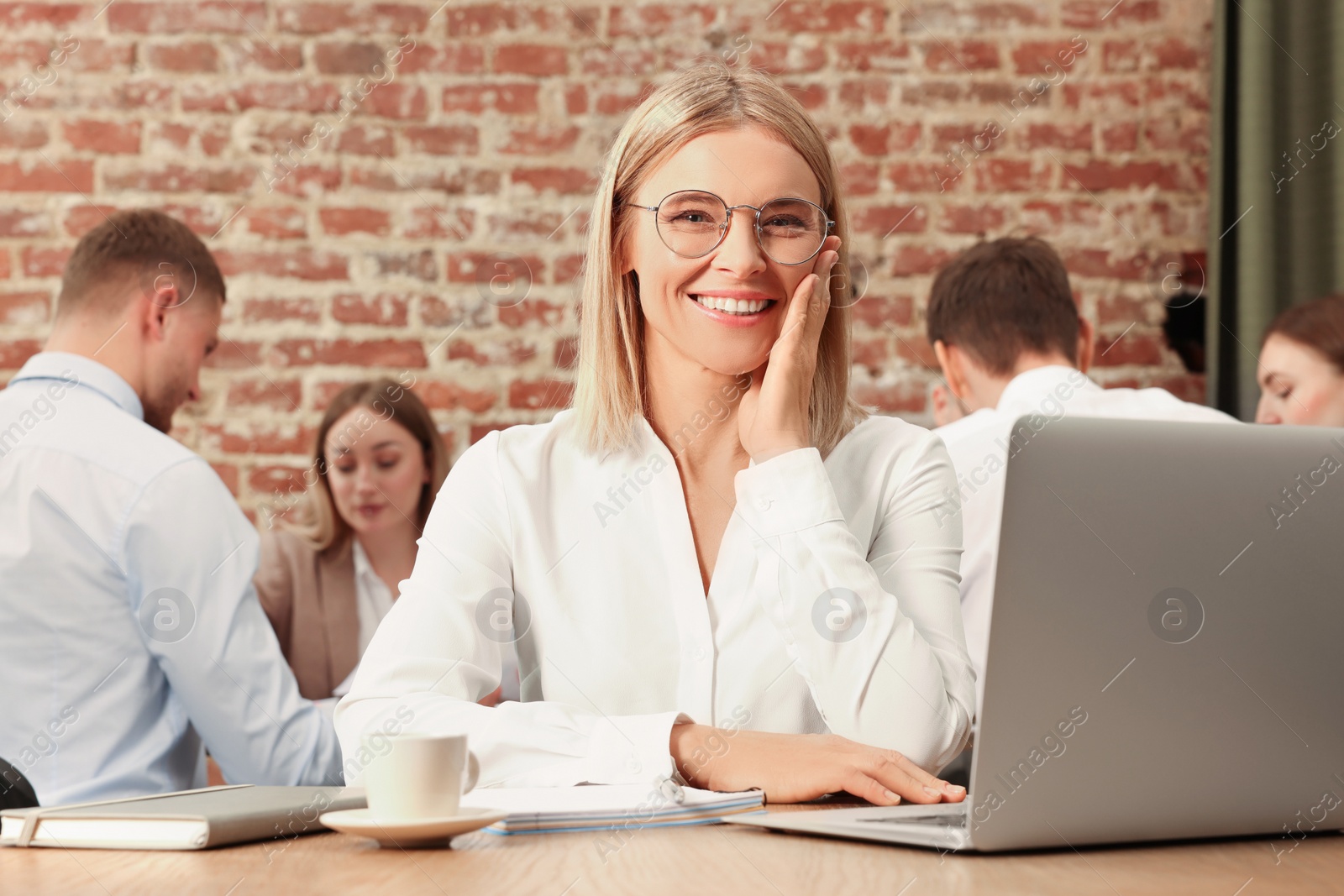 Photo of Businesswoman and her employees in office. Lady boss