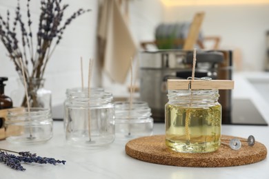 Glass jar with melted wax on white table, space for text. Handmade candle