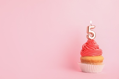 Photo of Birthday cupcake with number five candle on pink background, space for text
