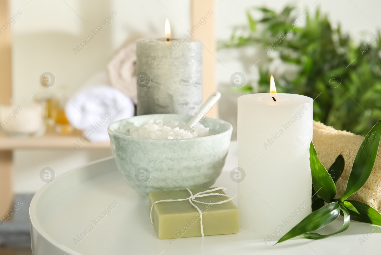 Photo of Beautiful spa composition with candles and cosmetic on white table, space for text