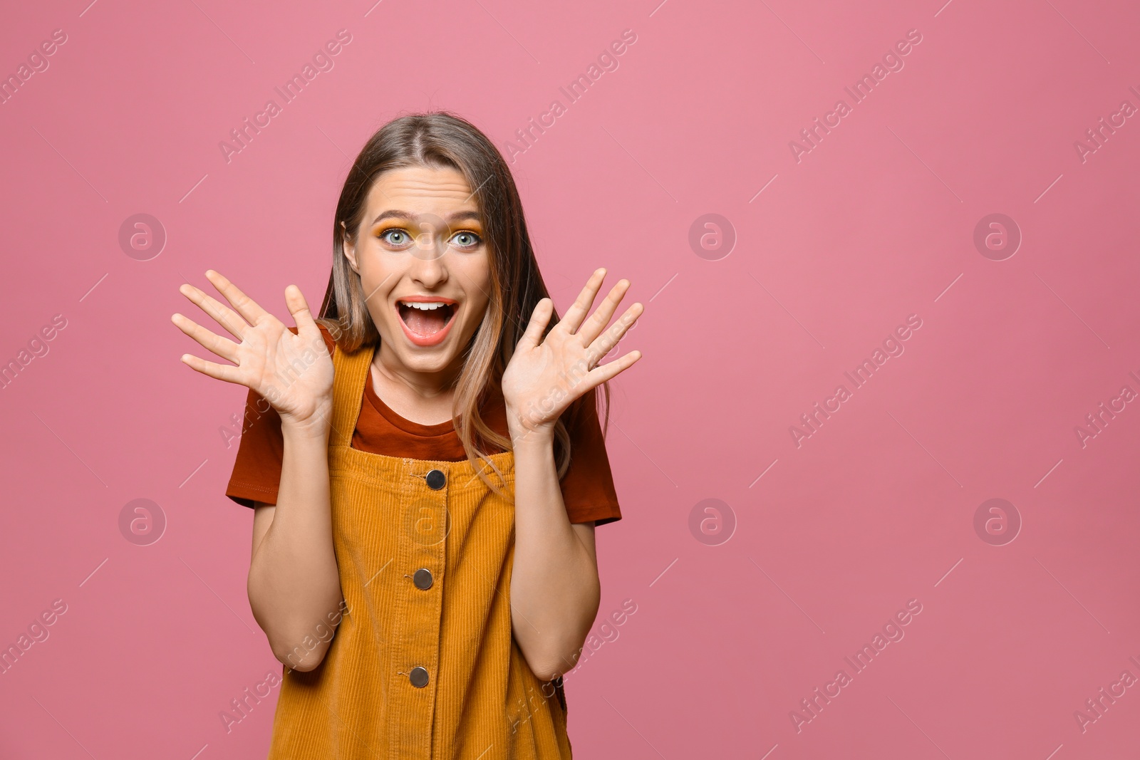 Photo of Excited teenage girl on pink background. Space for text