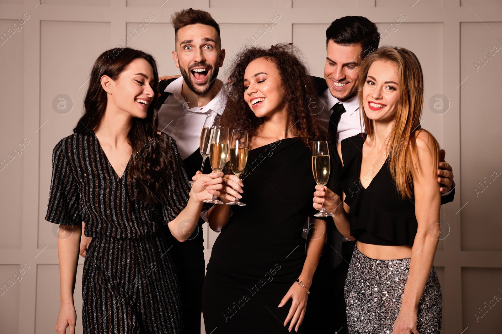 Photo of Happy friends with glasses of sparkling wine celebrating New Year indoors