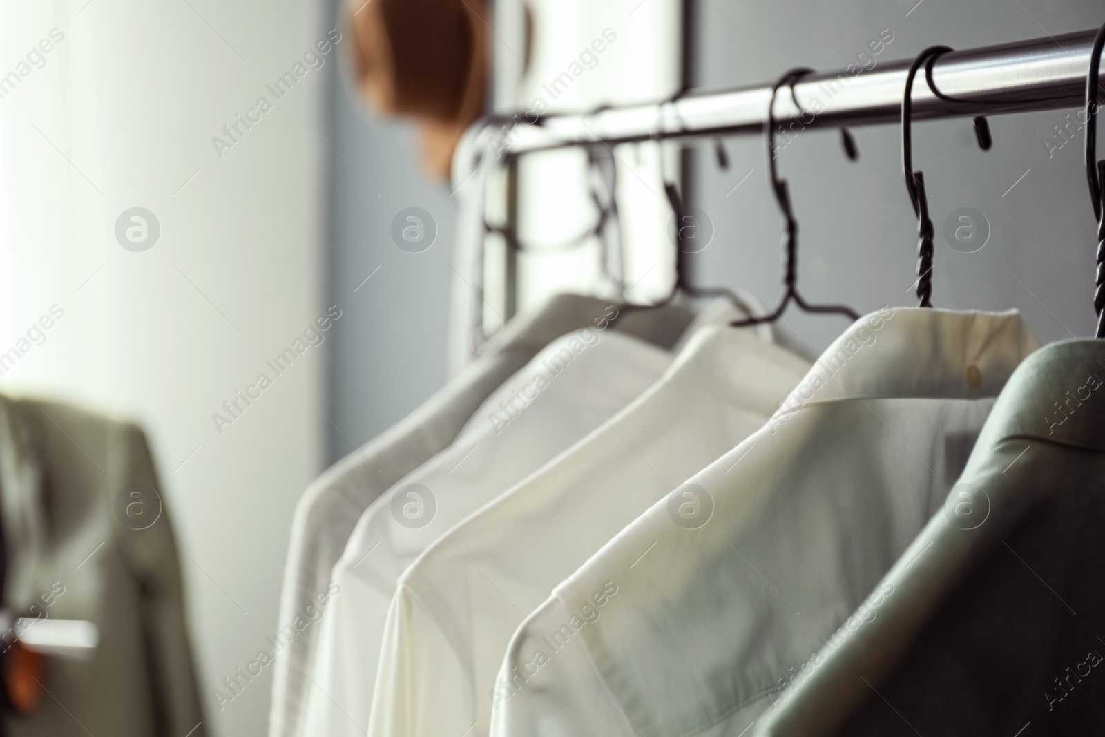 Photo of Rack with stylish men's clothes indoors, closeup. Interior design