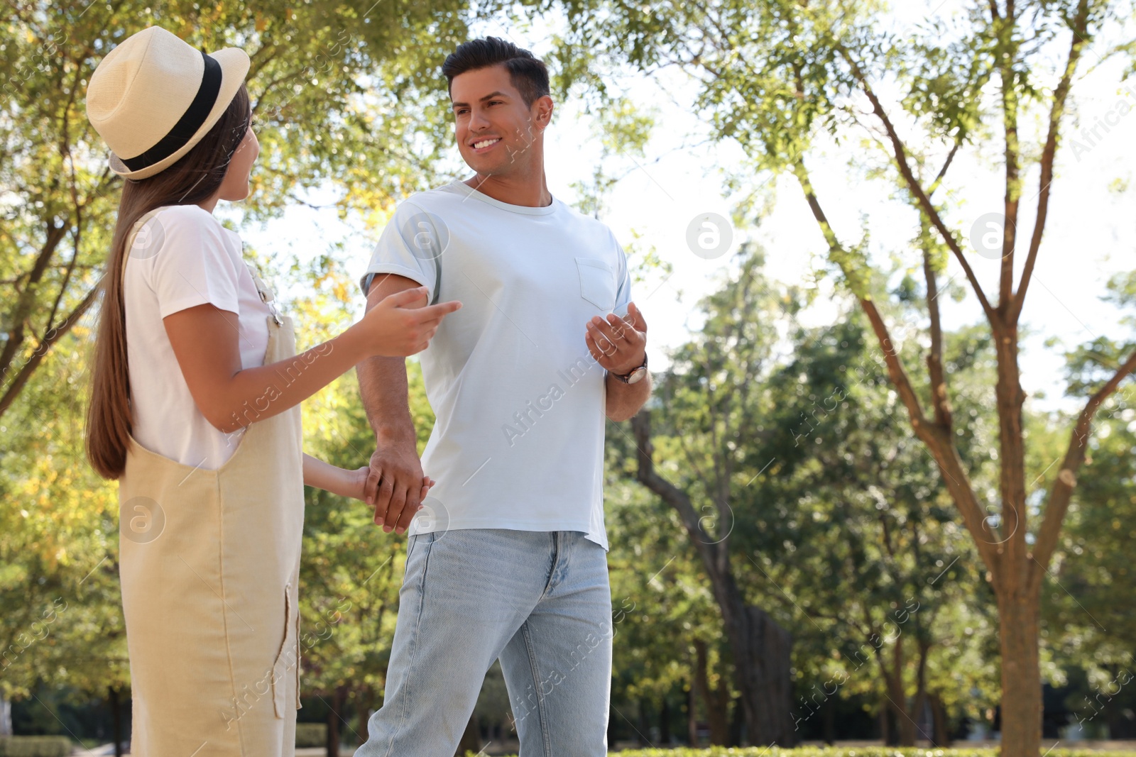 Photo of Lovely couple walking together in park on sunny day. Space for text