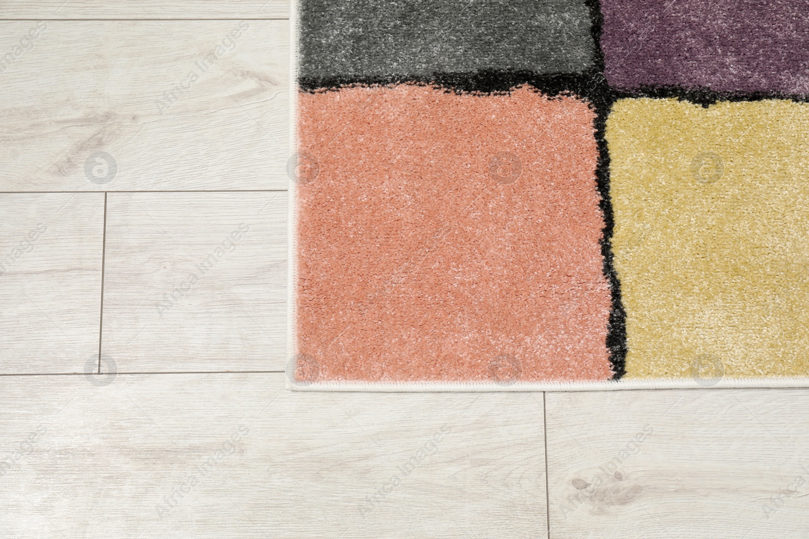 Photo of Soft carpet with pattern on white laminated floor indoors, top view