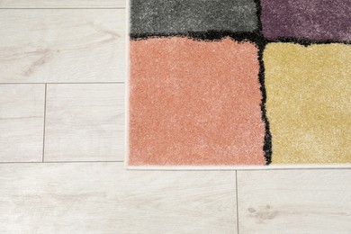 Photo of Soft carpet with pattern on white laminated floor indoors, top view