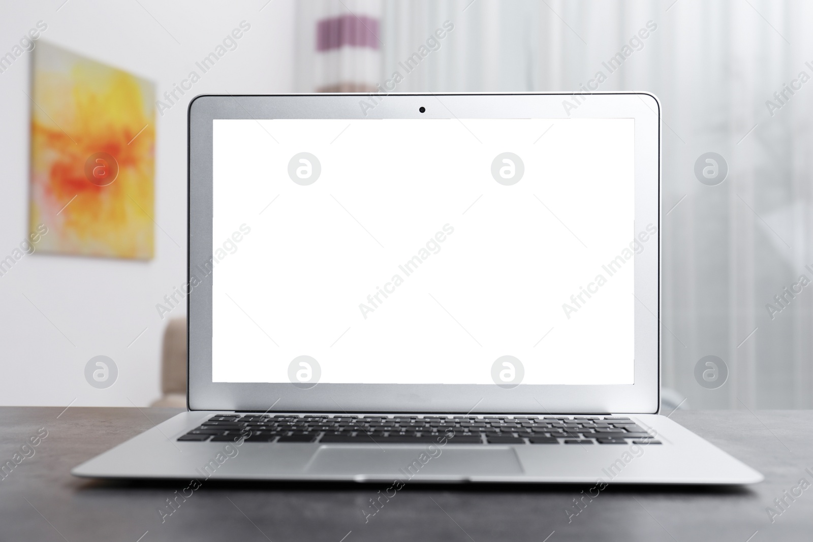 Photo of Modern laptop with blank screen on table indoors. Space for text