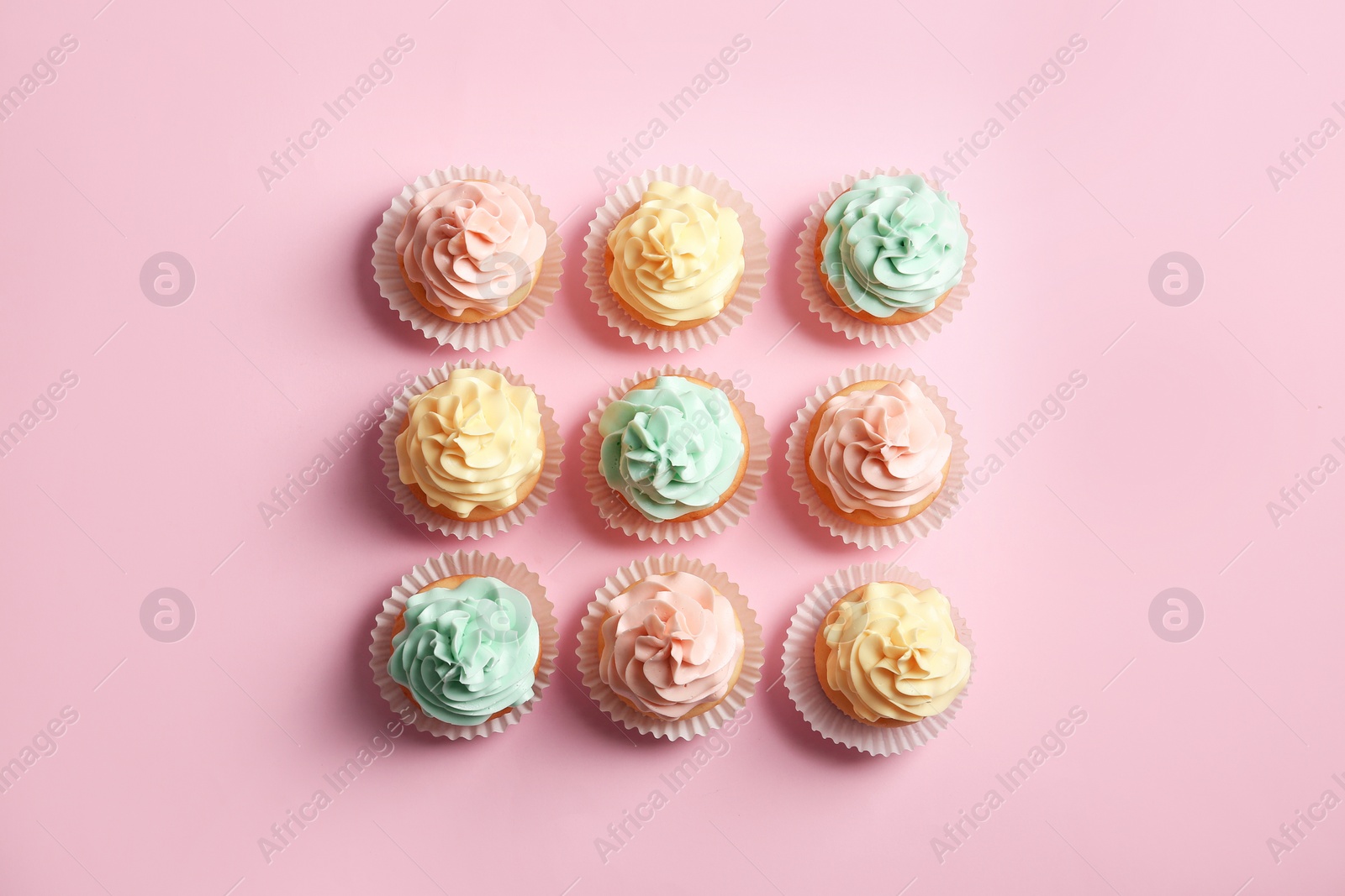 Photo of Flat lay composition with delicious cupcakes on color background